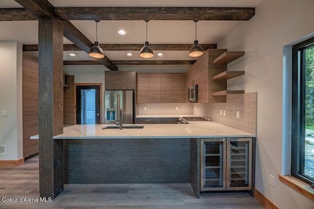 74 Wedge Ct, Priest Lake, ID 83856 - kitchen featuring stainless steel appliances, a peninsula, backsplash, beam ceiling, and modern cabinets