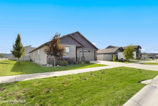 4447 N Connery Loop, Post Falls, ID 83854 - view of front of home with driveway, an attached garage, stone siding, and a residential view