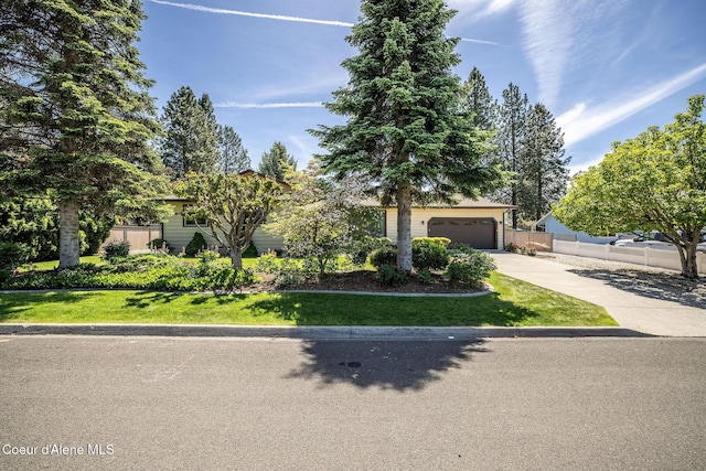 407 W Musket Ave, Post Falls, ID 83854 - view of property hidden behind natural elements with concrete driveway and a garage