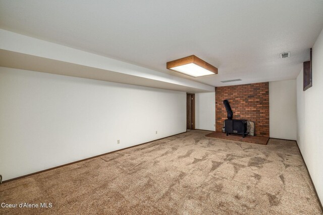 407 W Musket Ave, Post Falls, ID 83854 - unfurnished living room featuring a wood stove and carpet floors