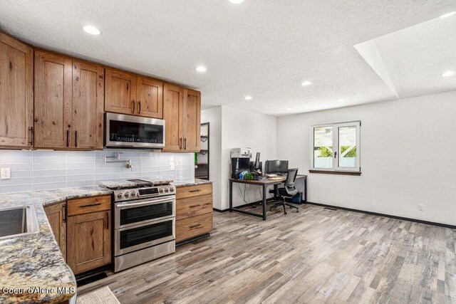 3623 W Hillcrest Cir, Coeur Dalene, ID 83815 - kitchen with appliances with stainless steel finishes, brown cabinets, light wood-type flooring, a textured ceiling, and recessed lighting