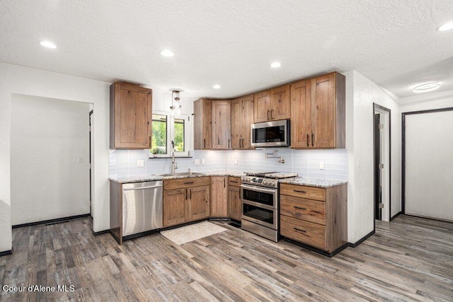 3623 W Hillcrest Cir, Coeur Dalene, ID 83815 - kitchen with stainless steel appliances, a sink, wood finished floors, tasteful backsplash, and a textured ceiling