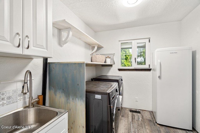 3623 W Hillcrest Cir, Coeur Dalene, ID 83815 - laundry room with cabinet space, separate washer and dryer, wood finished floors, and a textured ceiling