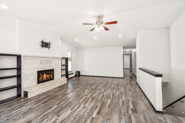 3623 W Hillcrest Cir, Coeur Dalene, ID 83815 - unfurnished living room featuring a ceiling fan, wood finished floors, a fireplace, vaulted ceiling, and recessed lighting