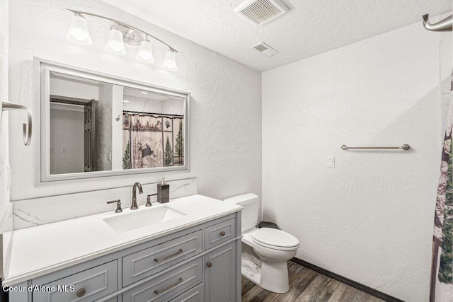 3623 W Hillcrest Cir, Coeur Dalene, ID 83815 - full bathroom with a textured wall, wood finished floors, toilet, vanity, and a textured ceiling