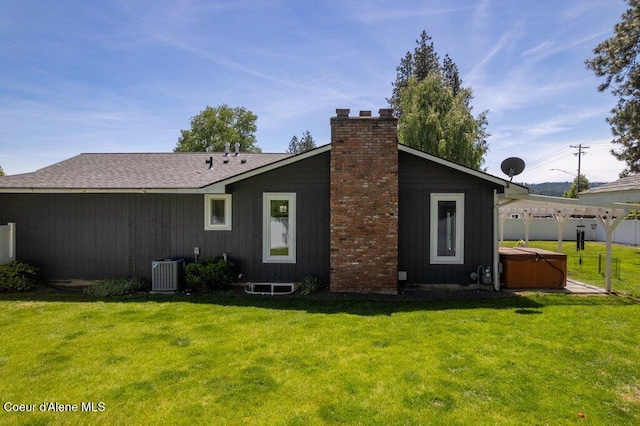 3623 W Hillcrest Cir, Coeur Dalene, ID 83815 - back of house featuring a hot tub, a chimney, a yard, and central air condition unit