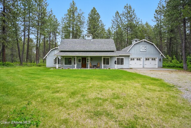 29808 N Caribou Ave, Athol, ID 83801 - view of front of home with covered porch, a front lawn, board and batten siding, gravel driveway, and a shingled roof