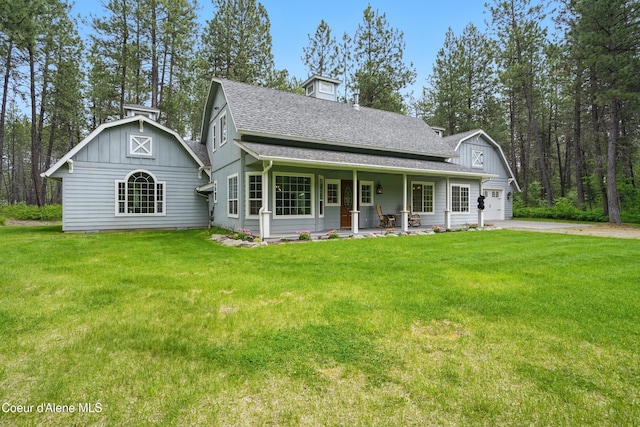 29808 N Caribou Ave, Athol, ID 83801 - view of front of home with a porch, a front yard, a shingled roof, a garage, and driveway