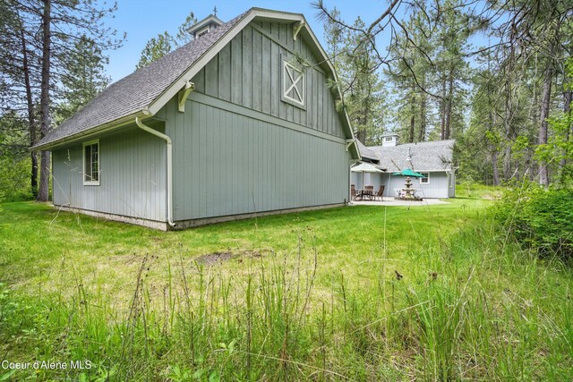 29808 N Caribou Ave, Athol, ID 83801 - view of home's exterior with roof with shingles, a barn, a lawn, an outdoor structure, and a patio area