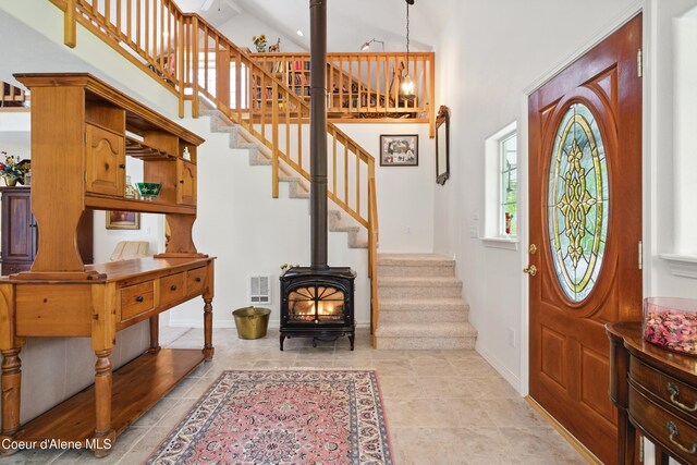 29808 N Caribou Ave, Athol, ID 83801 - foyer entrance with stairs, a wood stove, a towering ceiling, and light tile patterned flooring