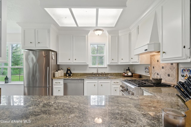 29808 N Caribou Ave, Athol, ID 83801 - kitchen featuring appliances with stainless steel finishes, custom exhaust hood, dark stone counters, and healthy amount of natural light