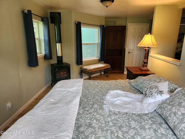 16488 N Atlas Rd, Rathdrum, ID 83858 - bedroom with a wood stove, wood finished floors, and baseboards