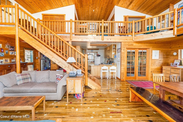 90 Bartoo Is Shr, Priest Lake, ID 83856 - living area with stairway, wood-type flooring, high vaulted ceiling, wood walls, and wooden ceiling