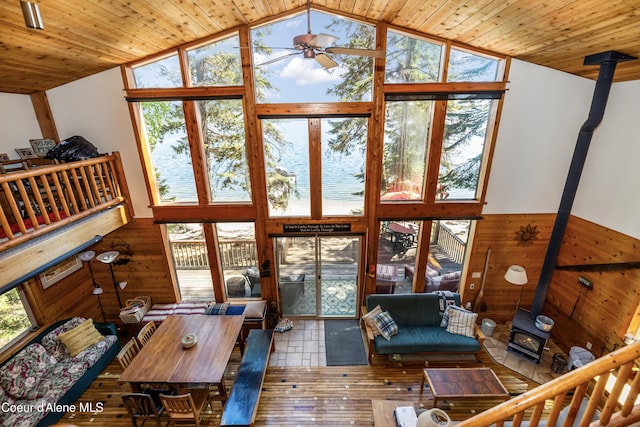 90 Bartoo Is Shr, Priest Lake, ID 83856 - living room featuring a wood stove, lofted ceiling, wooden walls, a ceiling fan, and wooden ceiling