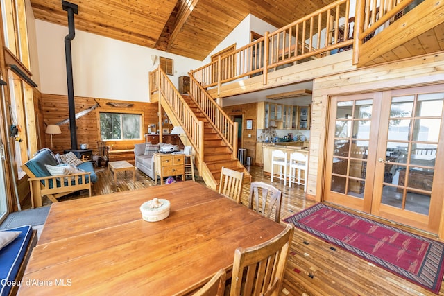 90 Bartoo Is Shr, Priest Lake, ID 83856 - dining area featuring a wood stove, high vaulted ceiling, wooden walls, wooden ceiling, and stairway