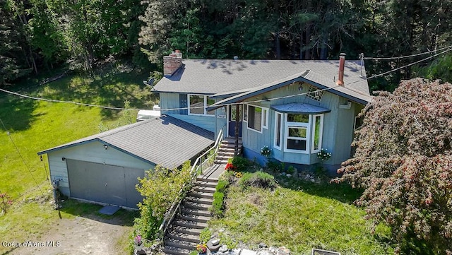 6214 Fir St, Bonners Ferry, ID 83805 - view of front facade featuring a chimney, stairs, a shingled roof, and a front yard