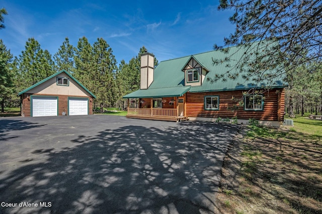 27294 N Clagstone Rd, Athol, ID 83801 - log home featuring a garage, log exterior, covered porch, an outdoor structure, and a chimney