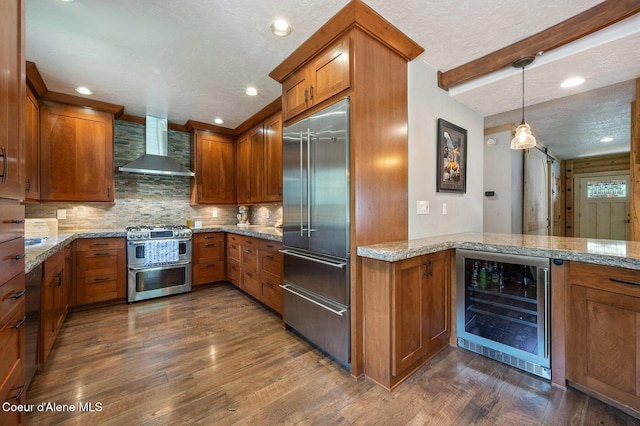 27294 N Clagstone Rd, Athol, ID 83801 - kitchen featuring stainless steel appliances, wine cooler, wall chimney range hood, brown cabinets, and dark wood finished floors