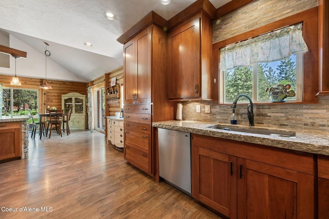 27294 N Clagstone Rd, Athol, ID 83801 - kitchen with dishwasher, brown cabinetry, a sink, decorative backsplash, and wood finished floors
