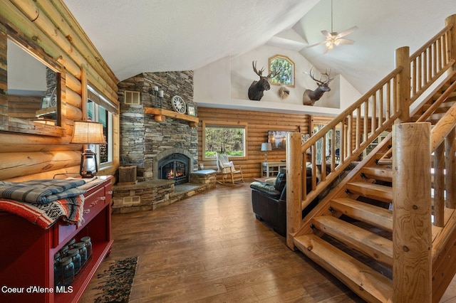27294 N Clagstone Rd, Athol, ID 83801 - living room featuring rustic walls, a ceiling fan, a stone fireplace, high vaulted ceiling, and stairs