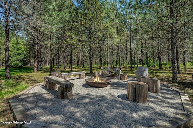 27294 N Clagstone Rd, Athol, ID 83801 - view of patio / terrace featuring an outdoor fire pit and a wooded view