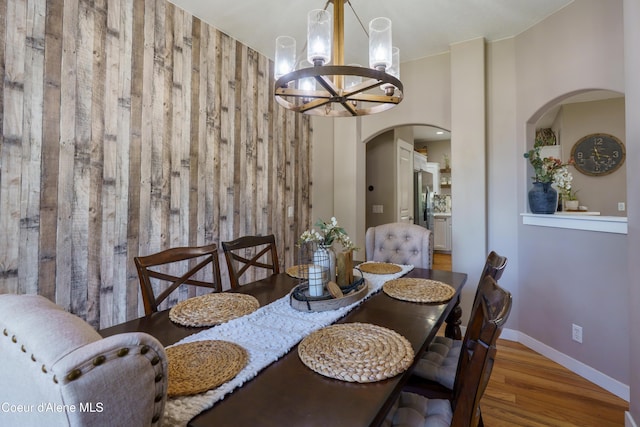 14717 N Nixon Loop, Rathdrum, ID 83858 - dining area with a chandelier, arched walkways, wood finished floors, wood walls, and baseboards