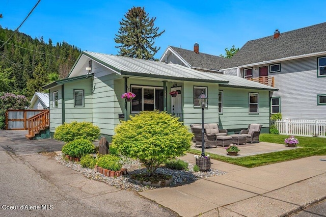 103 3rd St, Wallace, ID 83873 - view of front of home with outdoor lounge area, a patio area, and metal roof