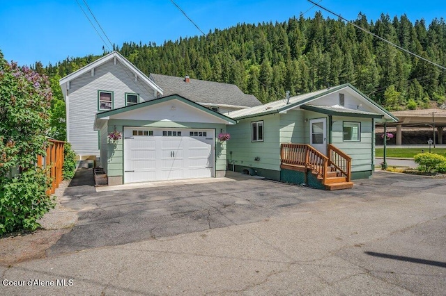 103 3rd St, Wallace, ID 83873 - view of front of house with a wooded view and asphalt driveway