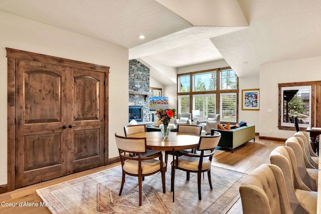 11690 N Arnicas Ct, Hayden, ID 83835 - dining area with light wood-style flooring, baseboards, a stone fireplace, recessed lighting, and lofted ceiling