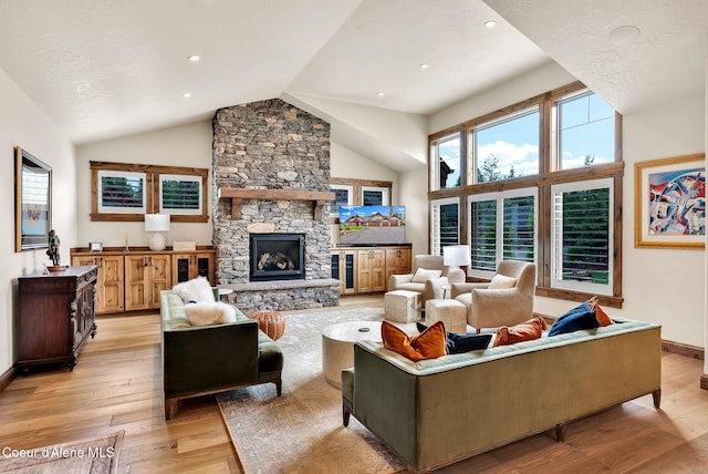 11690 N Arnicas Ct, Hayden, ID 83835 - living area with light wood finished floors, a stone fireplace, baseboards, recessed lighting, and high vaulted ceiling