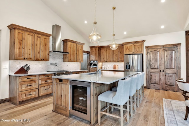 11690 N Arnicas Ct, Hayden, ID 83835 - kitchen featuring wall chimney range hood, beverage cooler, appliances with stainless steel finishes, lofted ceiling, and backsplash