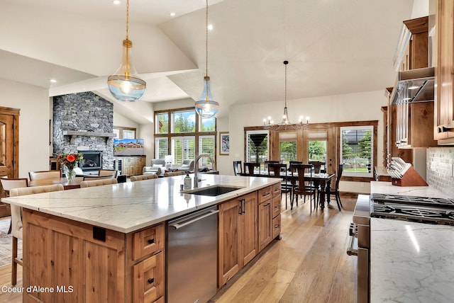 11690 N Arnicas Ct, Hayden, ID 83835 - kitchen with stainless steel appliances, a sink, high vaulted ceiling, an island with sink, and light wood-style floors