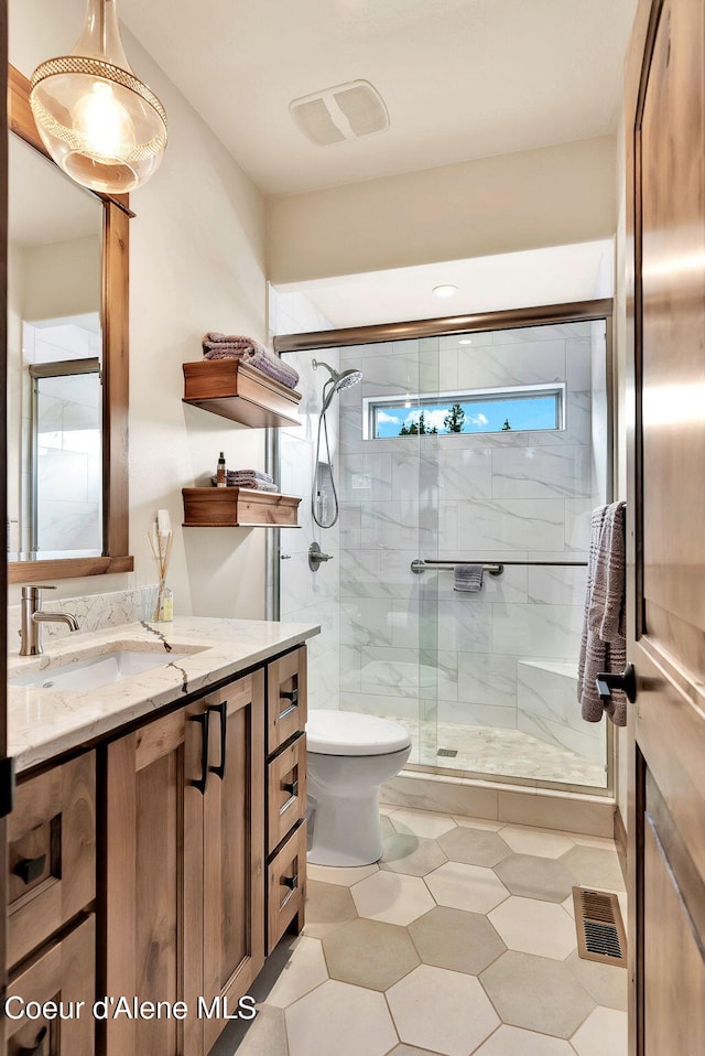 11690 N Arnicas Ct, Hayden, ID 83835 - bathroom with vanity, toilet, a stall shower, and tile patterned floors