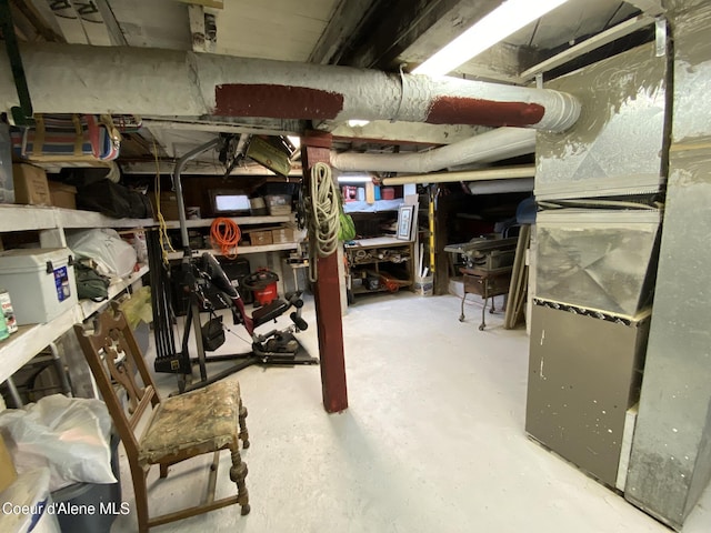176 King St, Wallace, ID 83873 - unfinished below grade area with heating unit and a workshop area