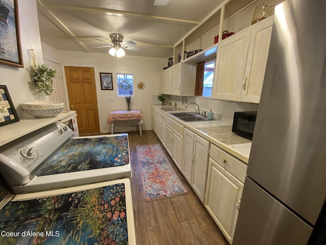 176 King St, Wallace, ID 83873 - kitchen featuring freestanding refrigerator, a sink, black microwave, dark wood-style flooring, and light countertops