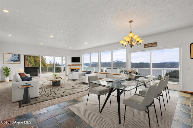 22884 S High Dr, Worley, ID 83876 - dining space featuring a chandelier, a textured ceiling, recessed lighting, stone tile floors, and a glass covered fireplace
