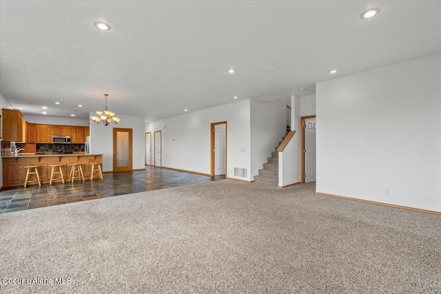 22884 S High Dr, Worley, ID 83876 - unfurnished living room with baseboards, a chandelier, dark carpet, recessed lighting, and stairway