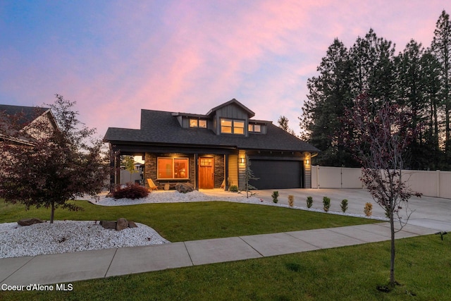 11387 N Armonia Way, Hayden Lake, ID 83835 - view of front of house with concrete driveway, covered porch, a gate, a garage, and stone siding
