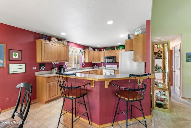 3391 W Loxton Loop, Coeur Dalene, ID 83815 - kitchen featuring white appliances, a kitchen breakfast bar, baseboards, light countertops, and a sink