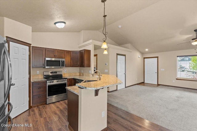 6463 W Conner St, Rathdrum, ID 83858 - kitchen with appliances with stainless steel finishes, a peninsula, vaulted ceiling, open floor plan, and a ceiling fan