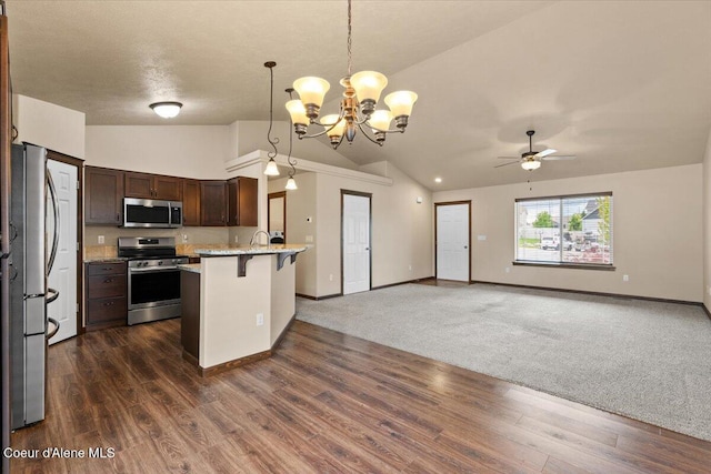 6463 W Conner St, Rathdrum, ID 83858 - kitchen with stainless steel appliances, vaulted ceiling, a peninsula, a kitchen bar, and open floor plan