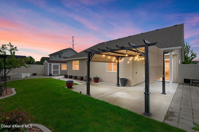 6463 W Conner St, Rathdrum, ID 83858 - back of property featuring a patio, a pergola, a storage unit, a fenced backyard, and a shingled roof