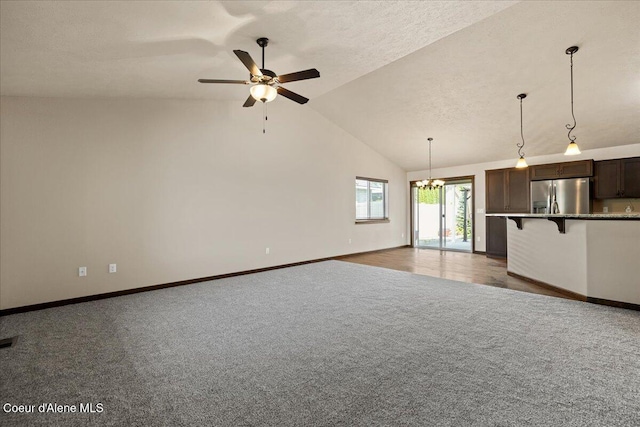 6463 W Conner St, Rathdrum, ID 83858 - unfurnished living room featuring carpet flooring, a chandelier, a ceiling fan, and vaulted ceiling