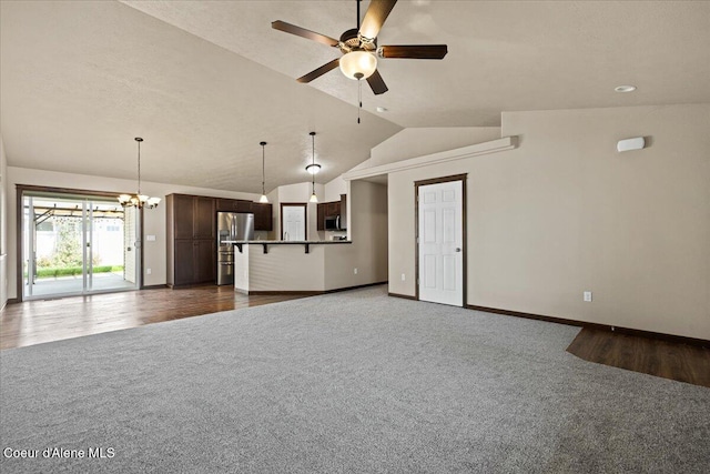 6463 W Conner St, Rathdrum, ID 83858 - unfurnished living room with dark carpet, lofted ceiling, a ceiling fan, and a chandelier