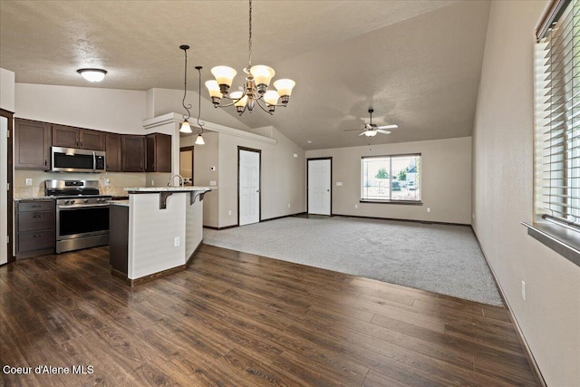 6463 W Conner St, Rathdrum, ID 83858 - kitchen featuring stainless steel appliances, vaulted ceiling, a breakfast bar, dark brown cabinets, and light countertops