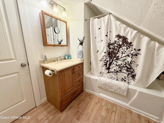 408 Quartz Crk Rd, Priest River, ID 83856 - full bath with a textured wall, shower / bath combo with shower curtain, vanity, wood finished floors, and a textured ceiling