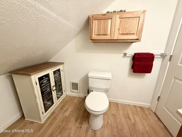 408 Quartz Crk Rd, Priest River, ID 83856 - bathroom with vaulted ceiling, wood finished floors, toilet, a textured ceiling, and baseboards