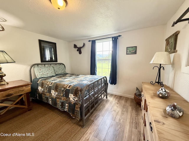 408 Quartz Crk Rd, Priest River, ID 83856 - bedroom with wood finished floors, a textured ceiling, and baseboards