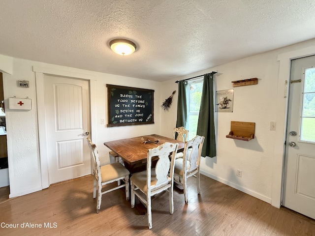 408 Quartz Crk Rd, Priest River, ID 83856 - dining area featuring a textured ceiling, wood finished floors, plenty of natural light, and baseboards