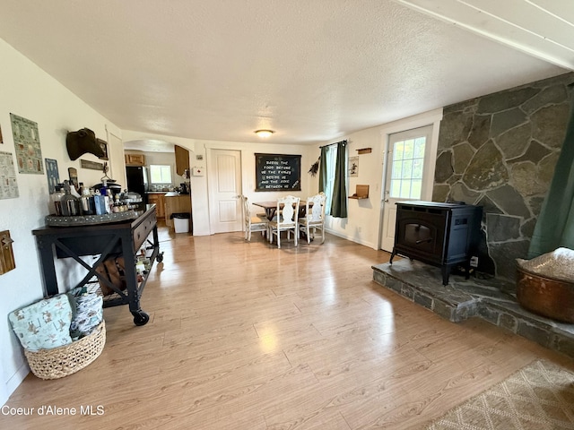 408 Quartz Crk Rd, Priest River, ID 83856 - living room with a wood stove, light wood finished floors, arched walkways, and a textured ceiling